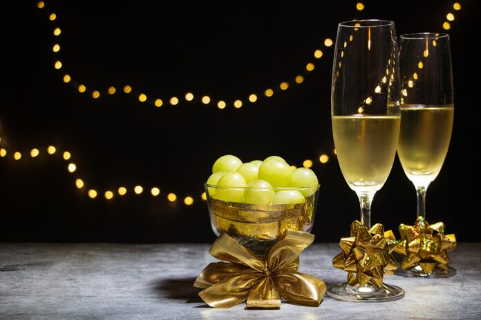 Two,Glasses,Of,Champagne,With,Twelve,Grapes