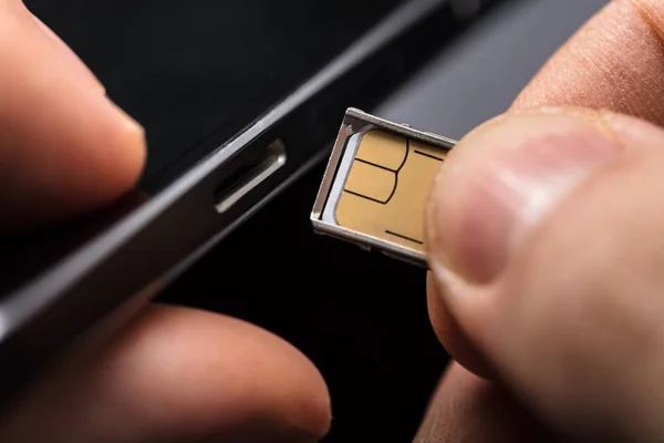 depositphotos_180433560-stock-photo-close-person-inserting-sim-card